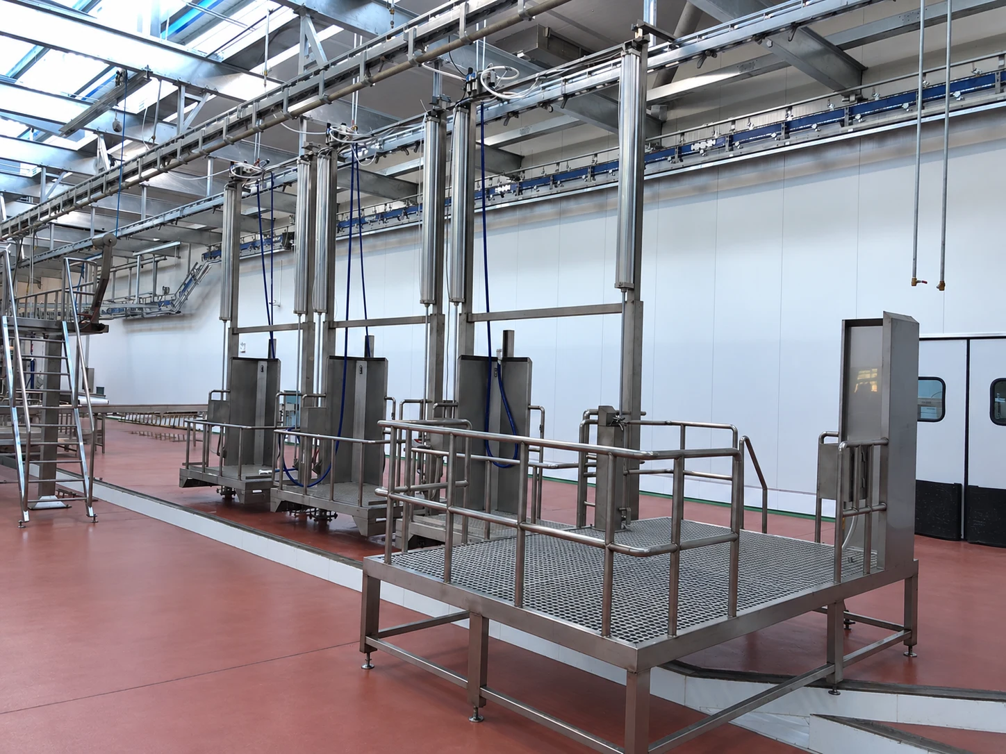 Cattle dressing rail and operator work platforms for rehanging and pre-skinning