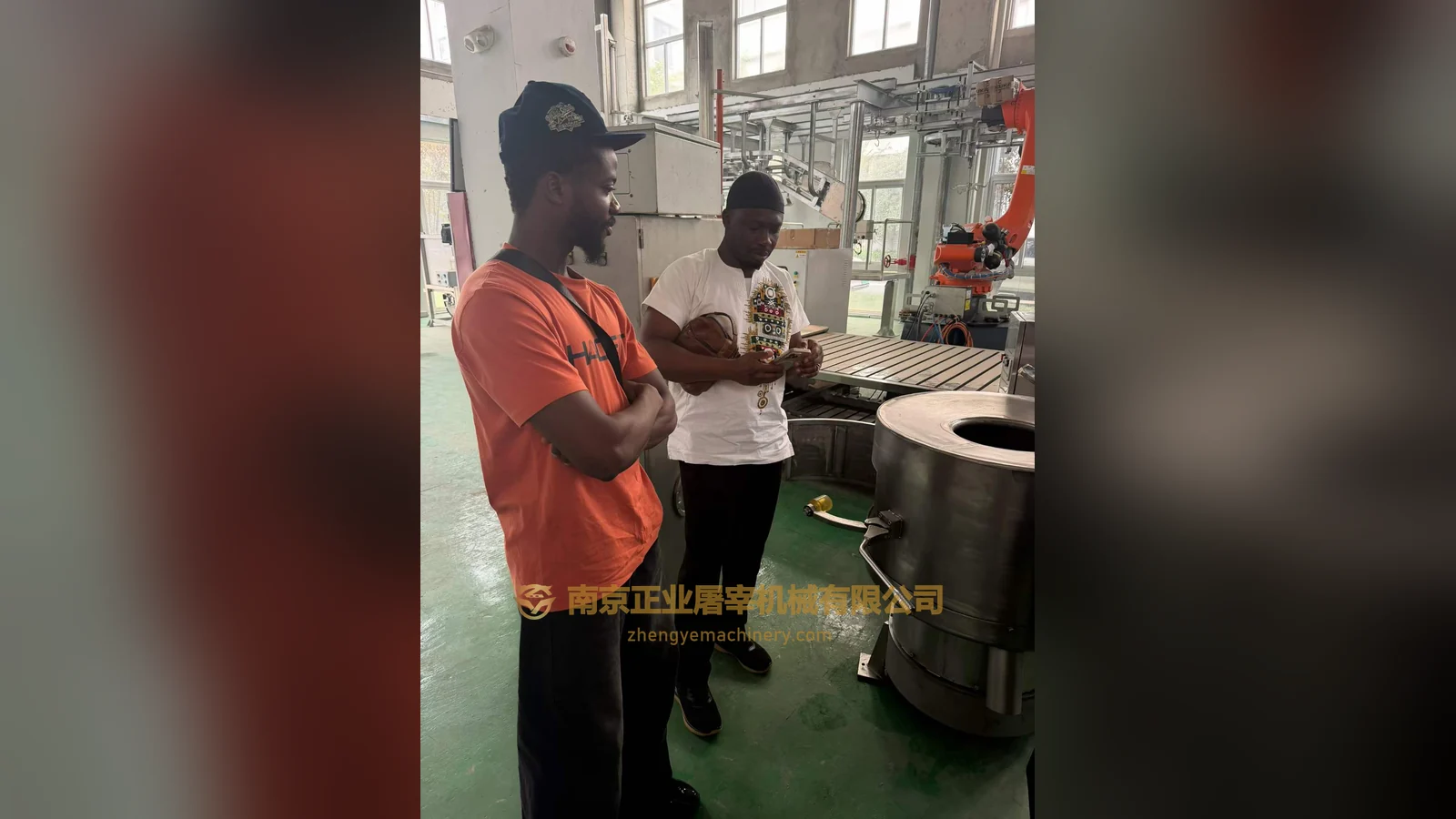 Visiting clients from Ghana beside equipment and a robotic arm