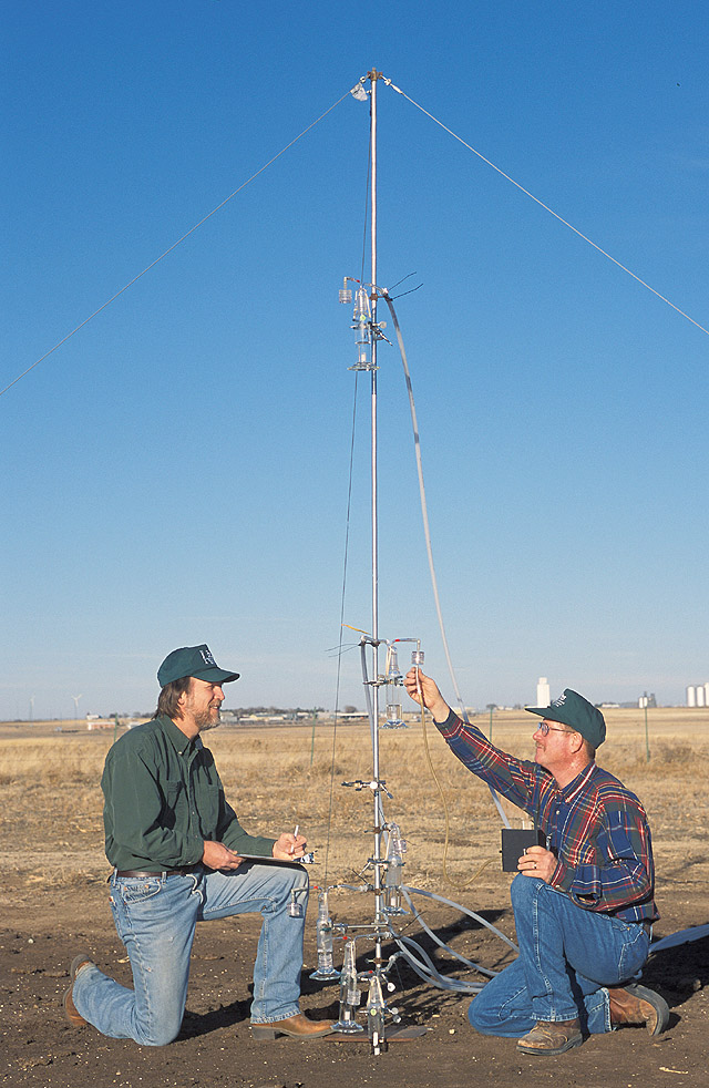 USDA ARS scientists measuring air flow at ammonia collectors on a simulated animal feedlot surface