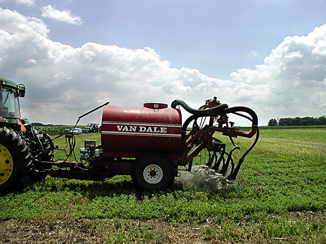 Research-scale applicator sprays swine manure on alfalfa in a USDA ARS archive photograph