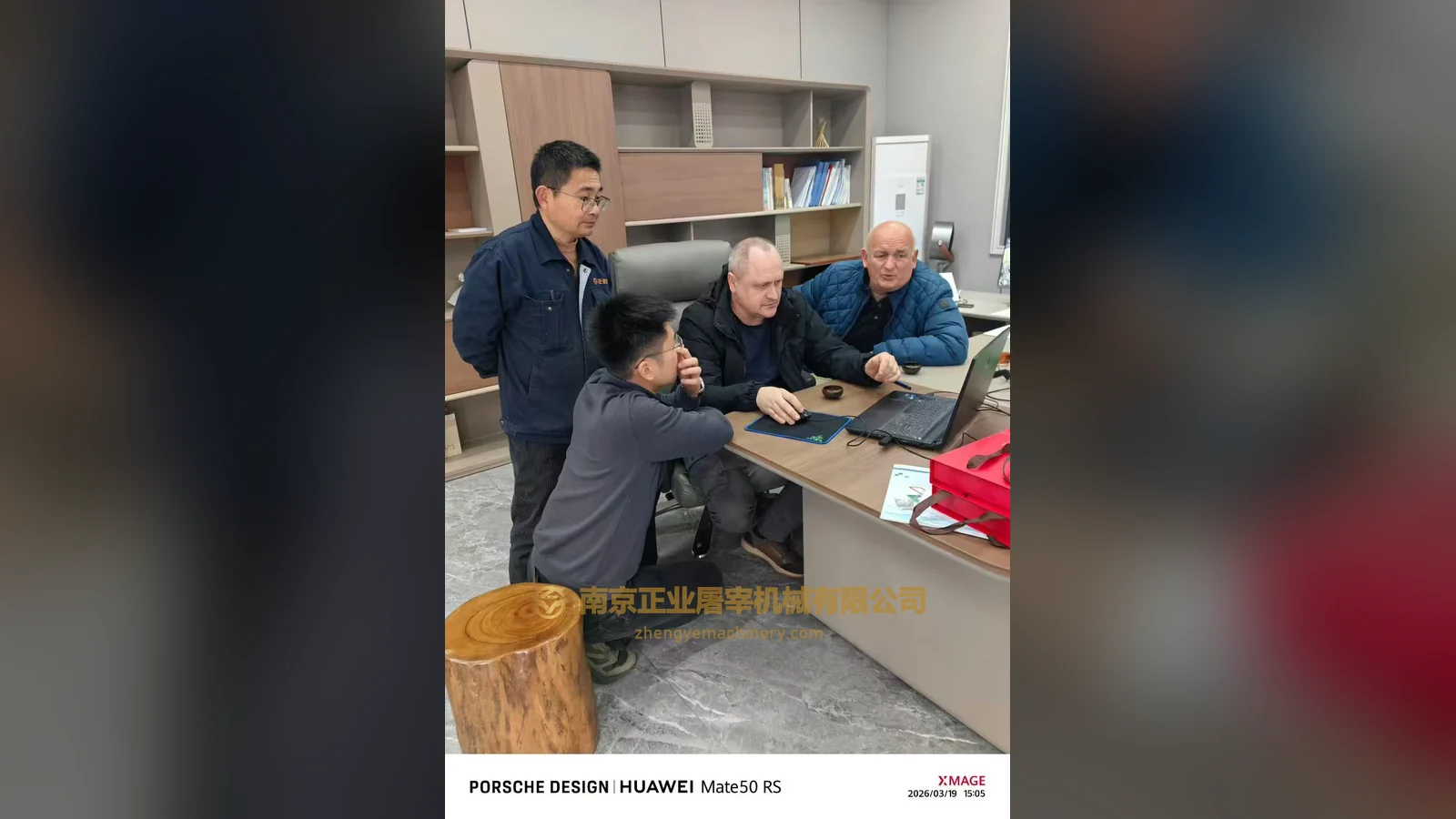 Visitors from Russia and Zhengye staff looking at a laptop screen